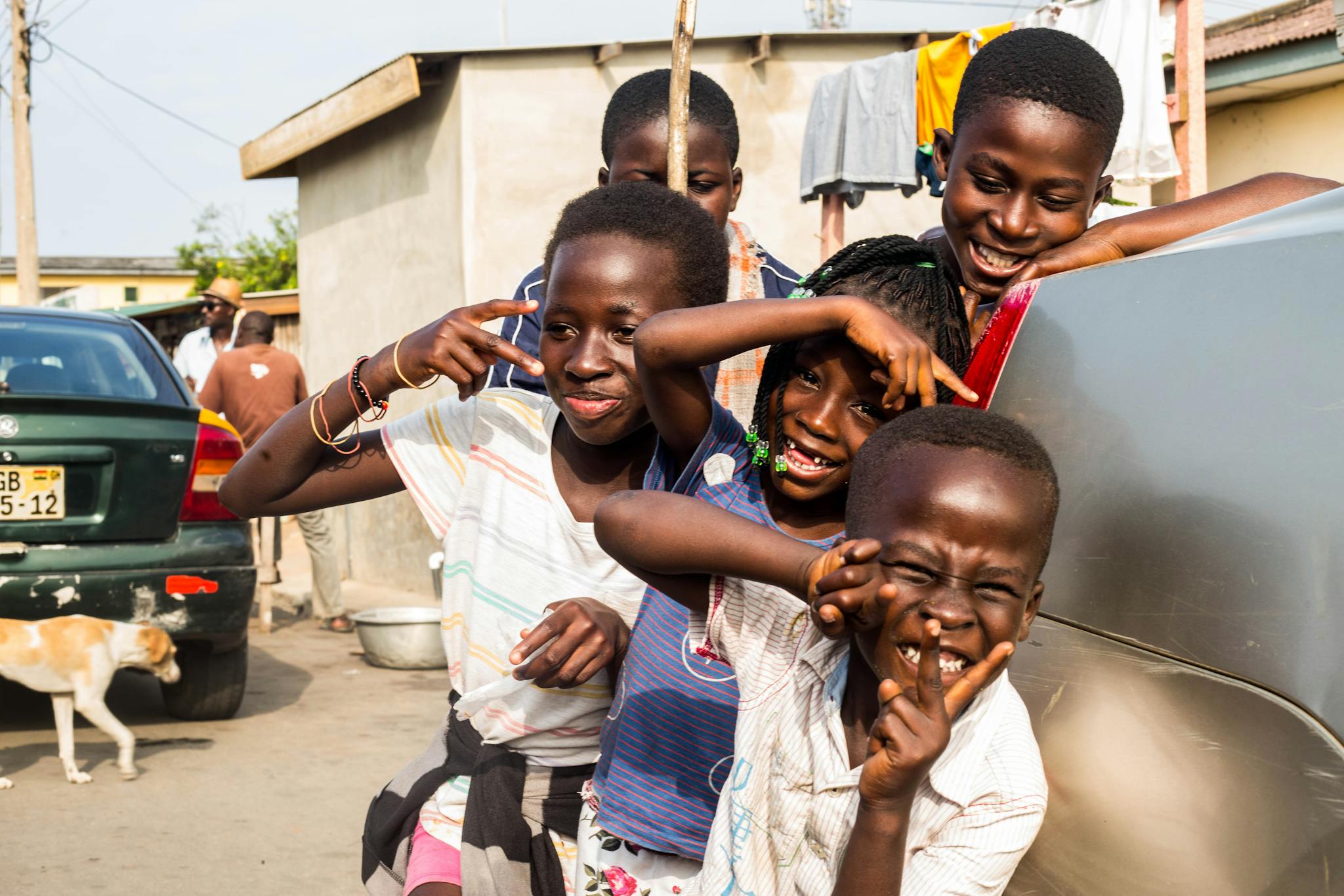 Group of happy children posing playfully outdoors, creating a joyful and energetic scene.